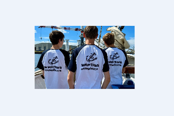 drei Kinder mit Mottoshirt von hinten auf einem Schiff